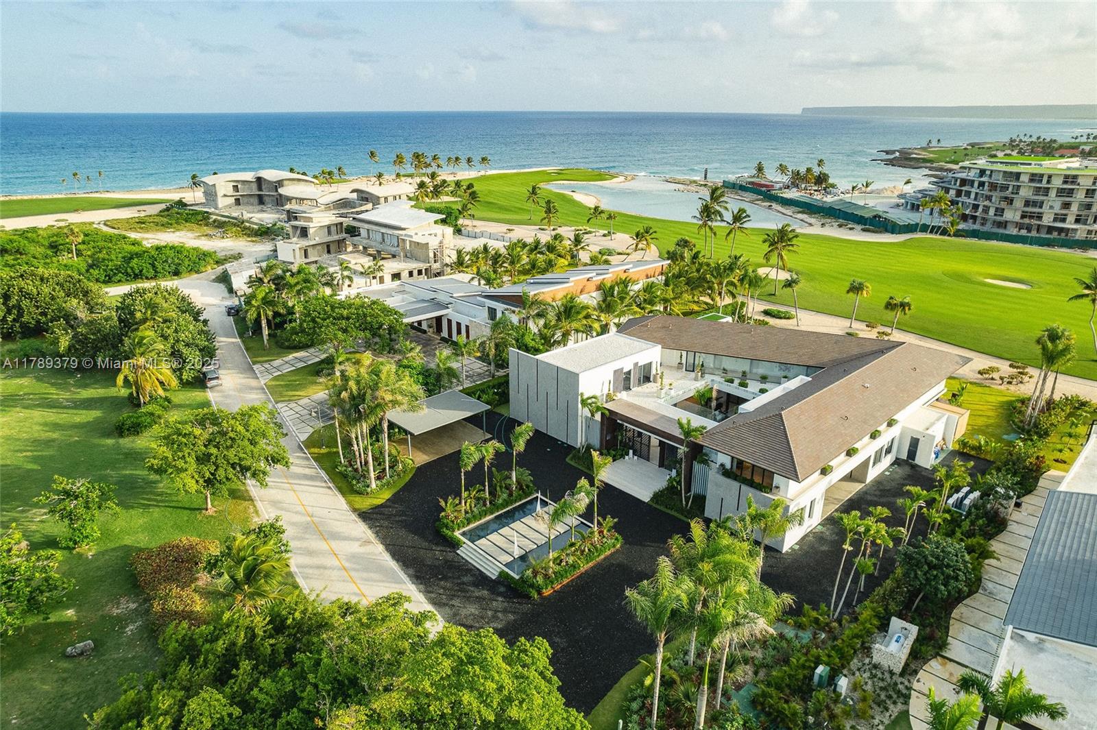 An aerial view shows a modern L-shaped villa situated near a golf course and ocean — 000 154 Cap Cana 23000, Dominican Republic, DR, DR