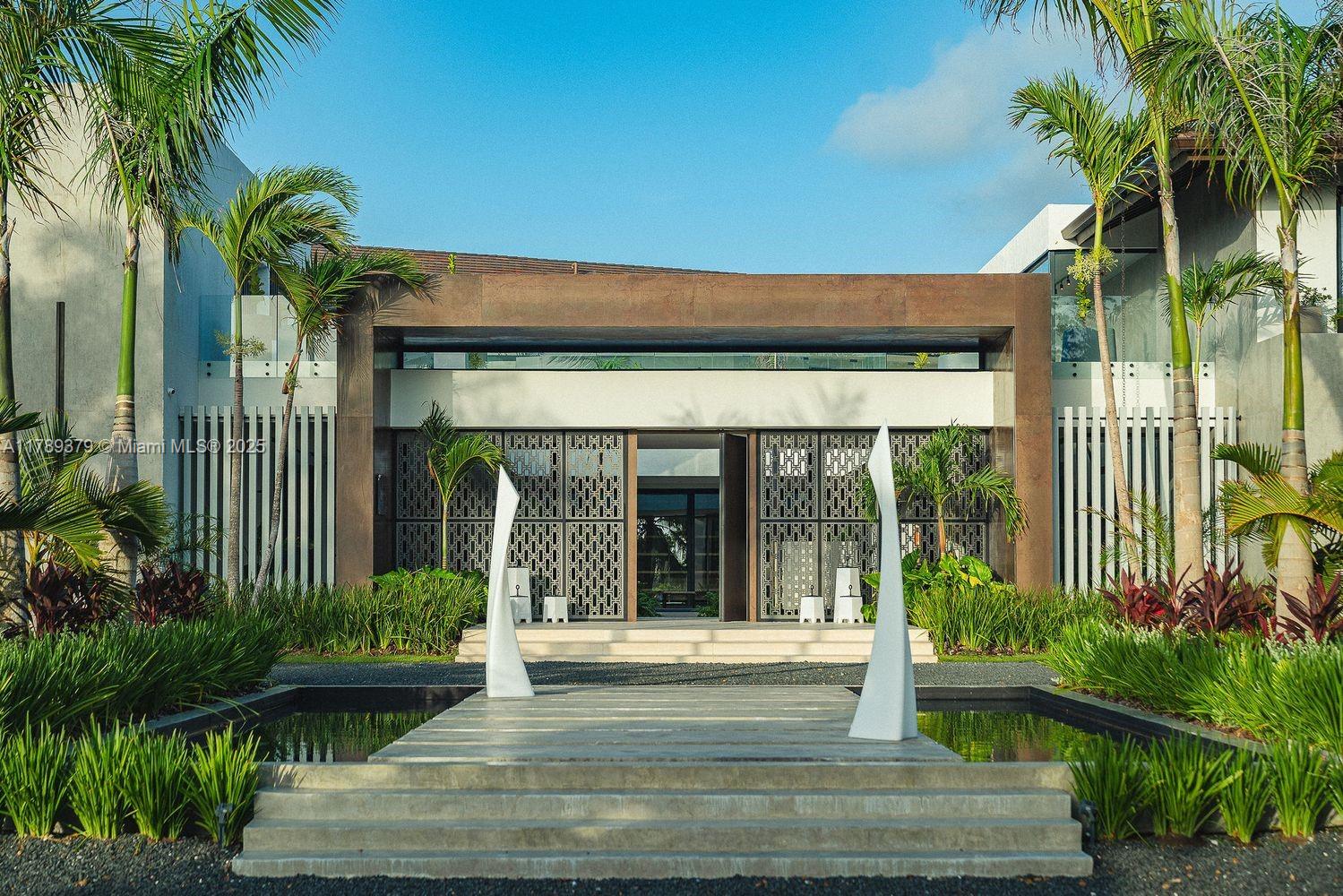 A modern house exterior features a stone walkway over a reflecting pool and decorative screens — 000 154 Cap Cana 23000, Dominican Republic, DR, DR
