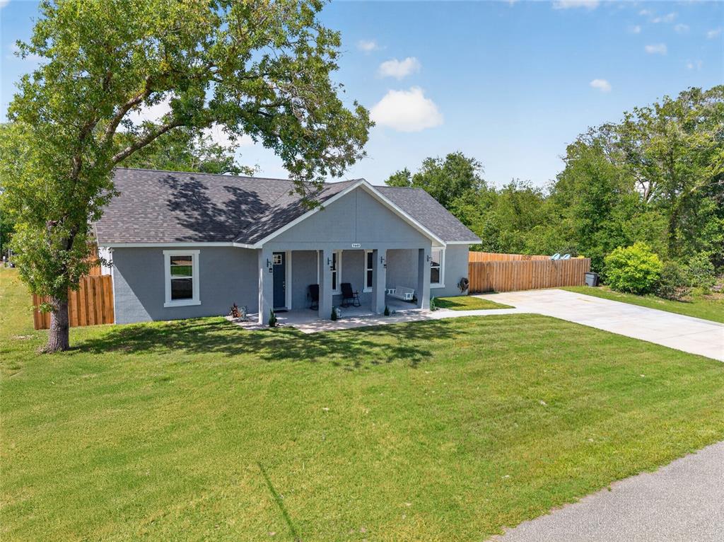 A gray, single-story house with a covered front porch and a concrete driveway — 9449 SE 158TH PLACE, SUMMERFIELD, FL