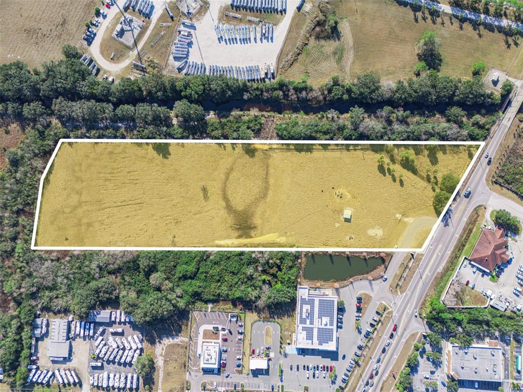 An aerial view shows a large, rectangular, grassy vacant lot bordered by trees and roads — THOMPSON NURSERY ROAD, LAKE WALES, FL