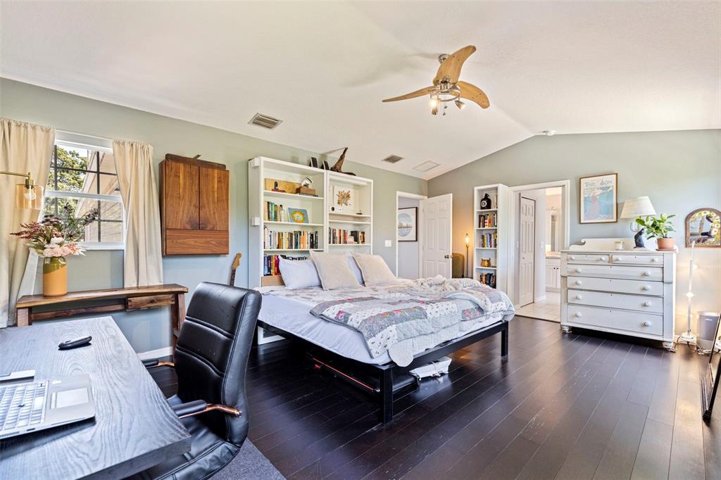 A bedroom with dark wood floors, a bed with bookshelves, a desk, and a dresser — 2462 14TH AVENUE N, ST PETERSBURG, FL