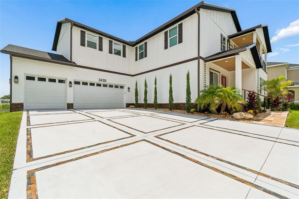 A two-story house with white siding, a multi-car garage, and a decorative concrete driveway — 3426 CHANNELSIDE COURT, SAFETY HARBOR, FL