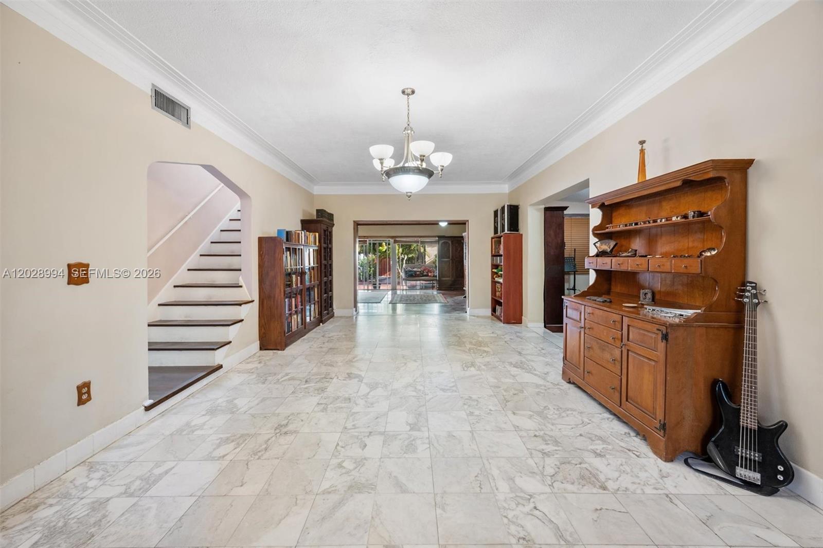 A spacious room features marble tile flooring, a staircase, and wooden furniture — 1727 SW 11th Ter, Miami FL 33135, MIAMI, FL