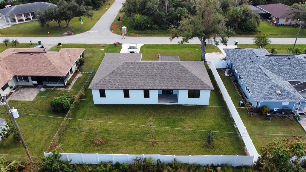 An aerial view shows a light blue house with a gray roof and a fenced backyard — 20296 RUTHERFORD AVENUE, PORT CHARLOTTE, FL