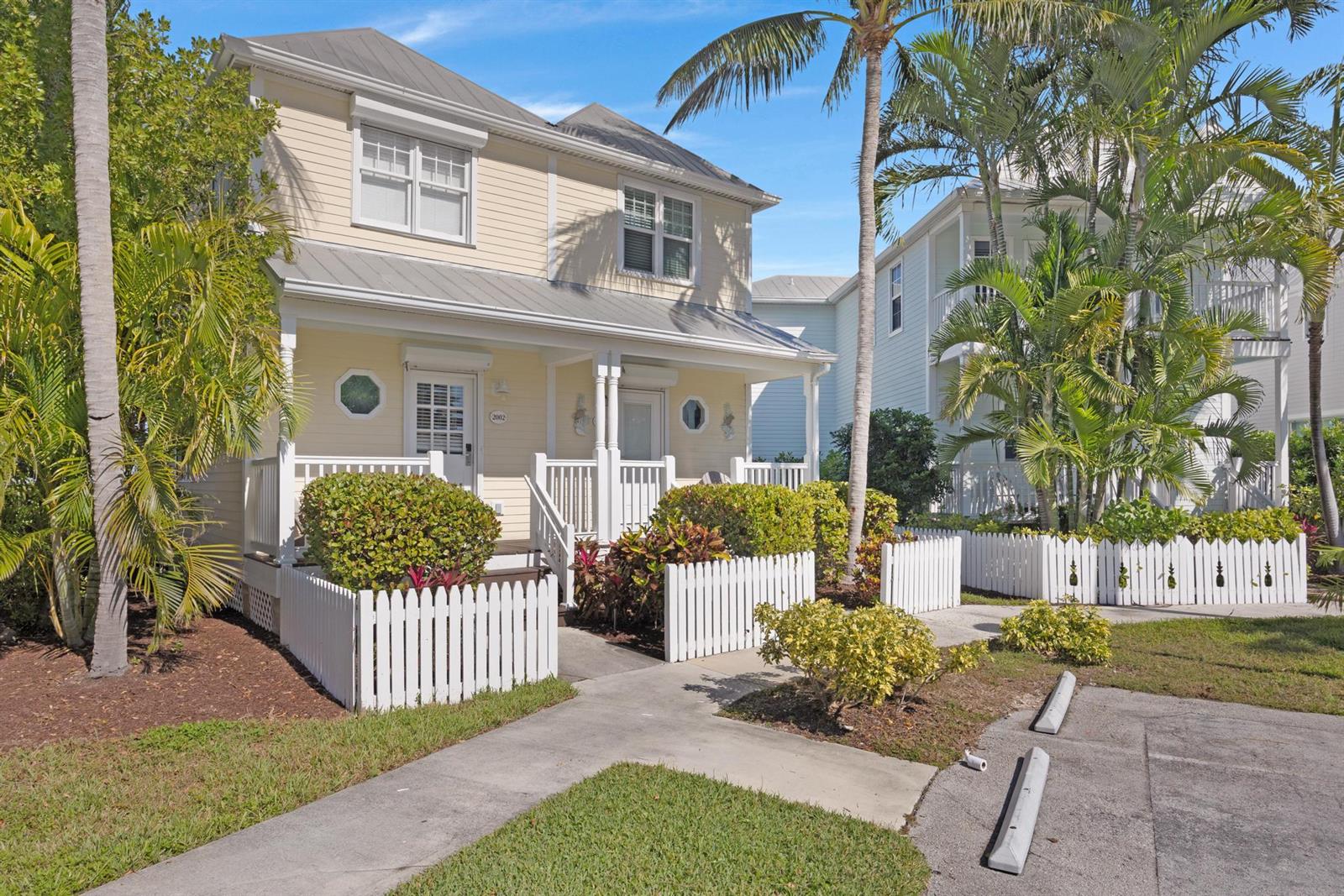 A two-story yellow house with a white picket fence and a metal roof — 2002 Marina Villa Drive, FL 33050, FL