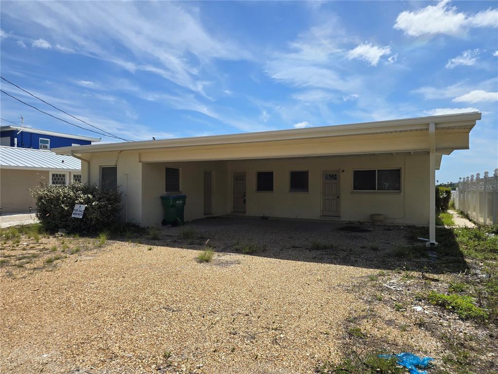A single-story house with a gravel driveway and a covered carport area — 249 144TH AVENUE, MADEIRA BEACH, FL