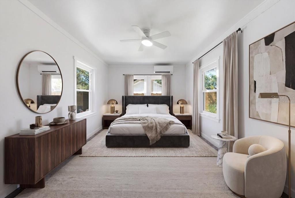 A modern bedroom features a dark upholstered bed, a wooden dresser, and a round mirror — 745 ALAMANDA WAY S, ST PETERSBURG, FL