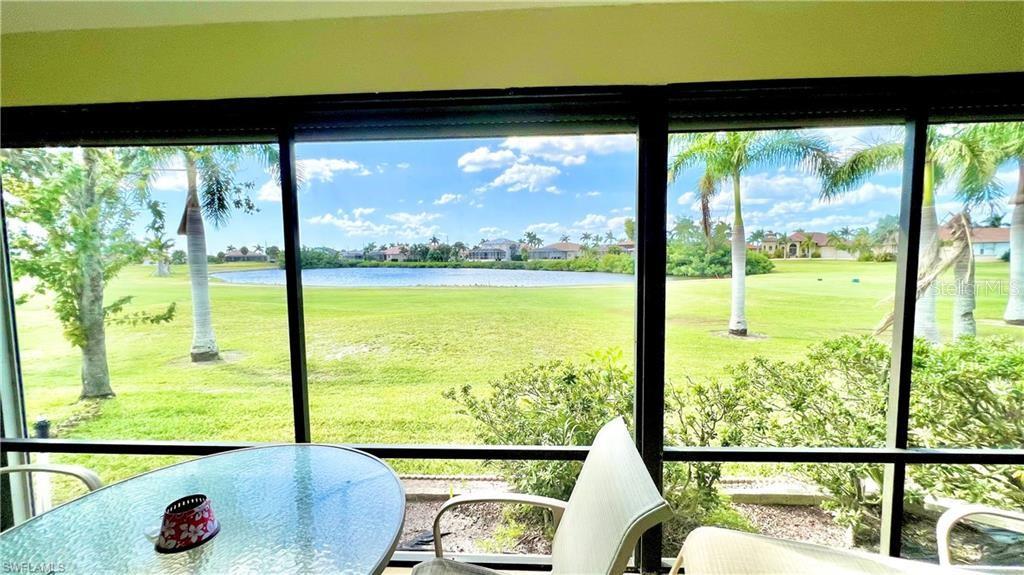 A view of a grassy lawn and a pond from a screened-in patio — 1640 ATARES DRIVE UNIT 31, PUNTA GORDA, FL