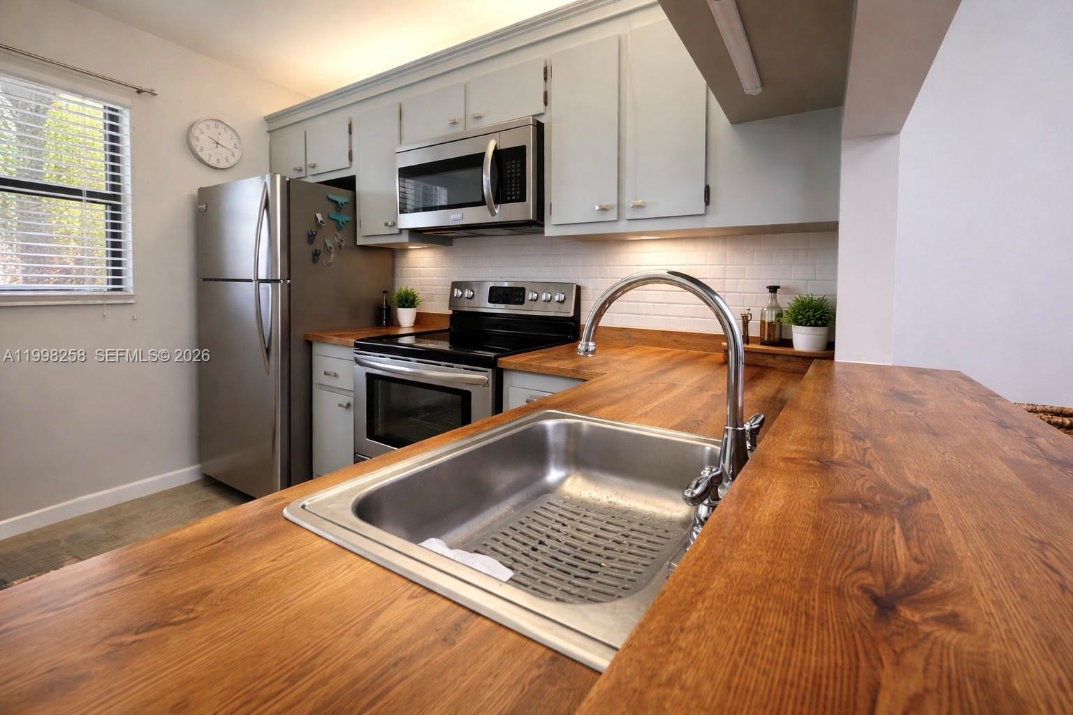 A two-story residential building features a balcony, a ground-level entrance, and lush landscaping — 7269 Golf Colony Ct # 202, Lake Worth FL 33467, LAKE WORTH, FL