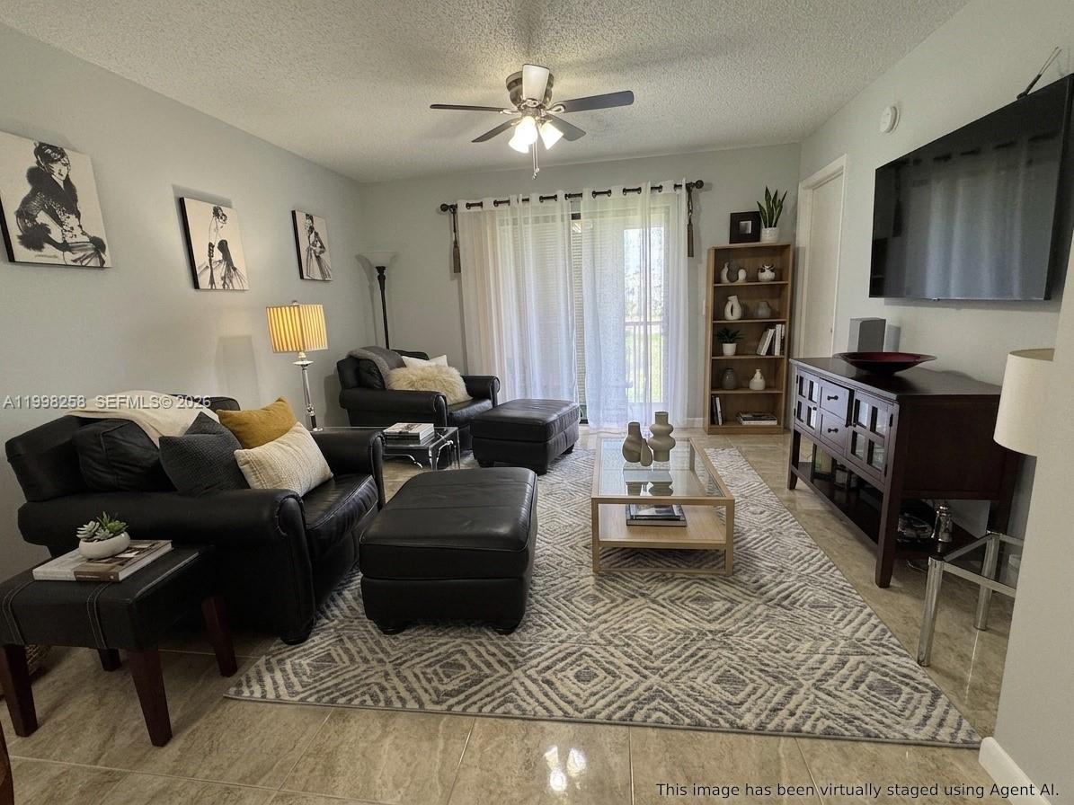 This living room features tile flooring, a ceiling fan, and a large area rug — 7269 Golf Colony Ct # 202, Lake Worth FL 33467, LAKE WORTH, FL