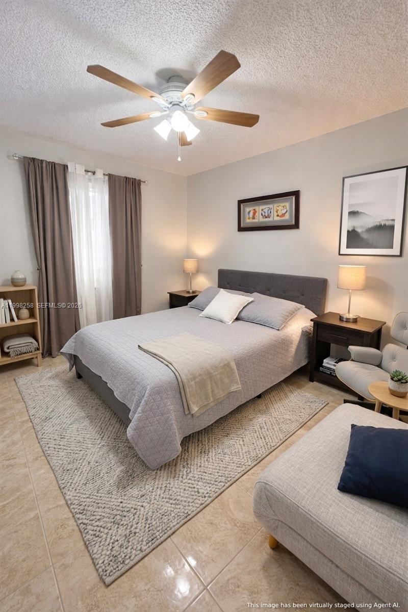 A bedroom features a gray bed, two nightstands with lamps, a ceiling fan, and tile flooring — 7269 Golf Colony Ct # 202, Lake Worth FL 33467, LAKE WORTH, FL