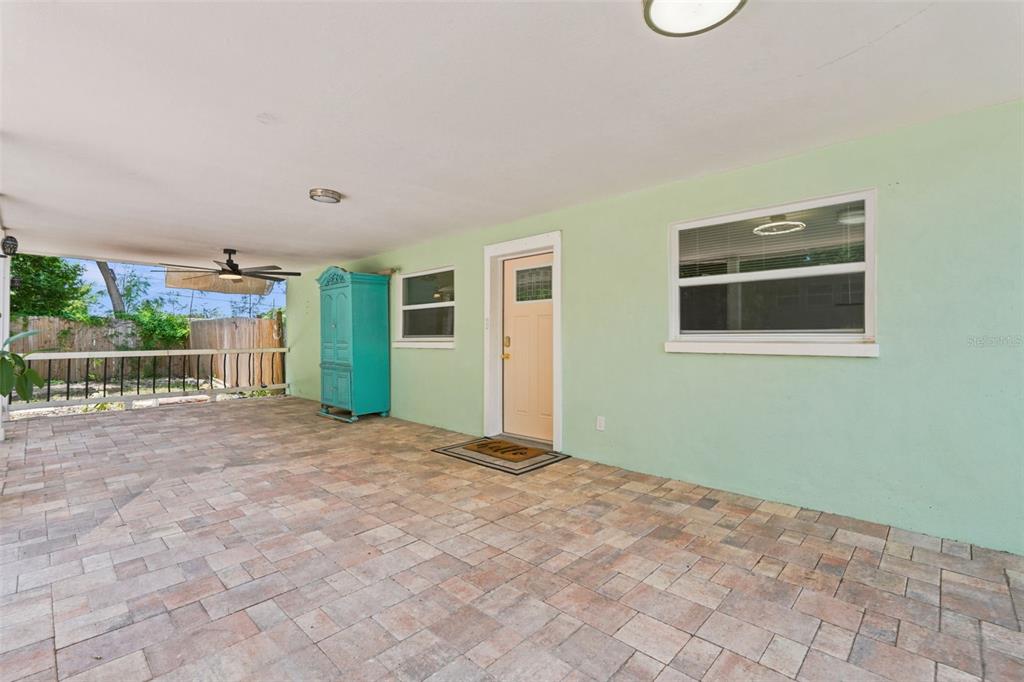 A covered patio features light green walls, a tiled floor, and a turquoise cabinet — 6691 56TH AVENUE N, ST PETERSBURG, FL