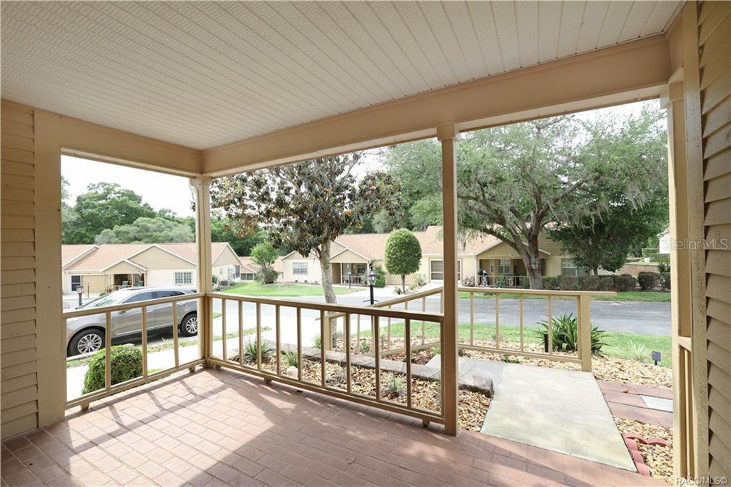 A covered porch with a tiled floor overlooks a residential street and neighboring houses — 3637 N LAURELWOOD LOOP, BEVERLY HILLS, FL
