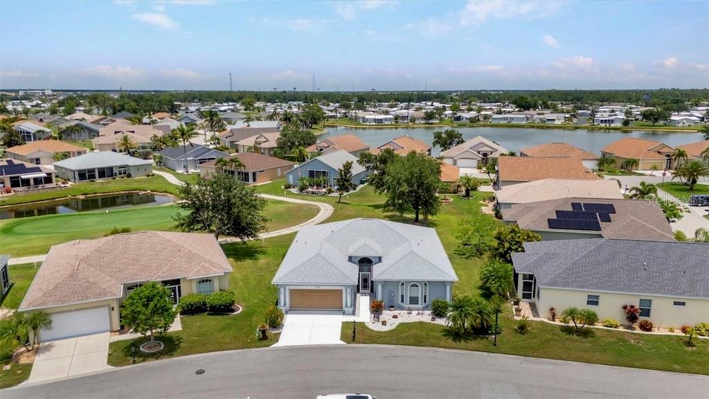 An aerial view shows a suburban house with a gray roof and garage — 24312 WESTGATE BOULEVARD, PUNTA GORDA, FL
