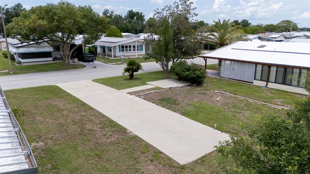 An elevated view shows a concrete driveway and yard in front of a mobile home — 35100 COLONY HILLS DRIVE, ZEPHYRHILLS, FL