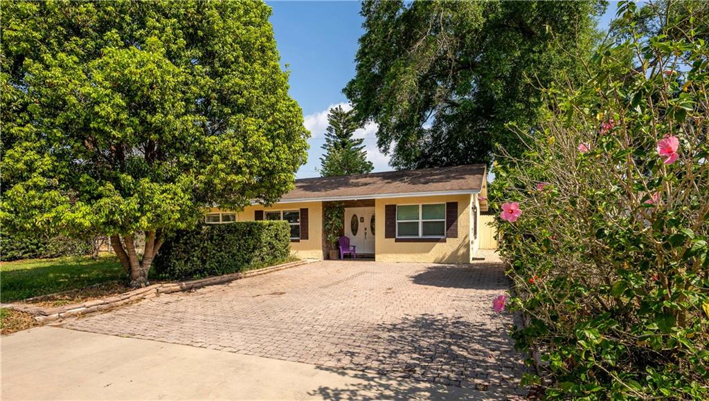 A single-story house with a paved driveway, a large tree, and a purple chair — 2721 RAEFORD ROAD, ORLANDO, FL