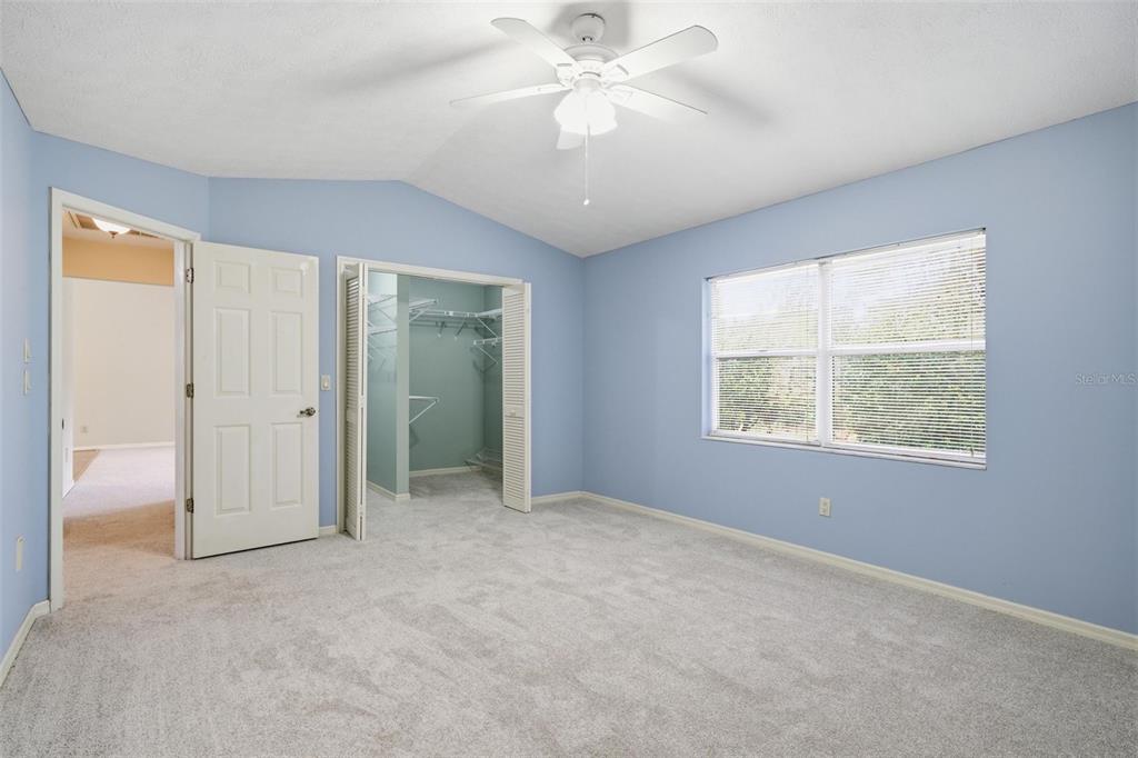 A bedroom with light blue walls, gray carpet, a ceiling fan, and an open closet — 6068 W DOUNERAY LOOP, CRYSTAL RIVER, FL