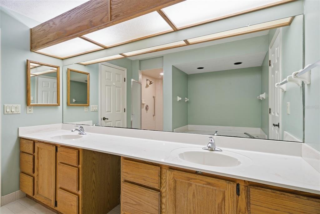 A bathroom features a double vanity with wood cabinets, a large mirror, and overhead lighting — 6068 W DOUNERAY LOOP, CRYSTAL RIVER, FL