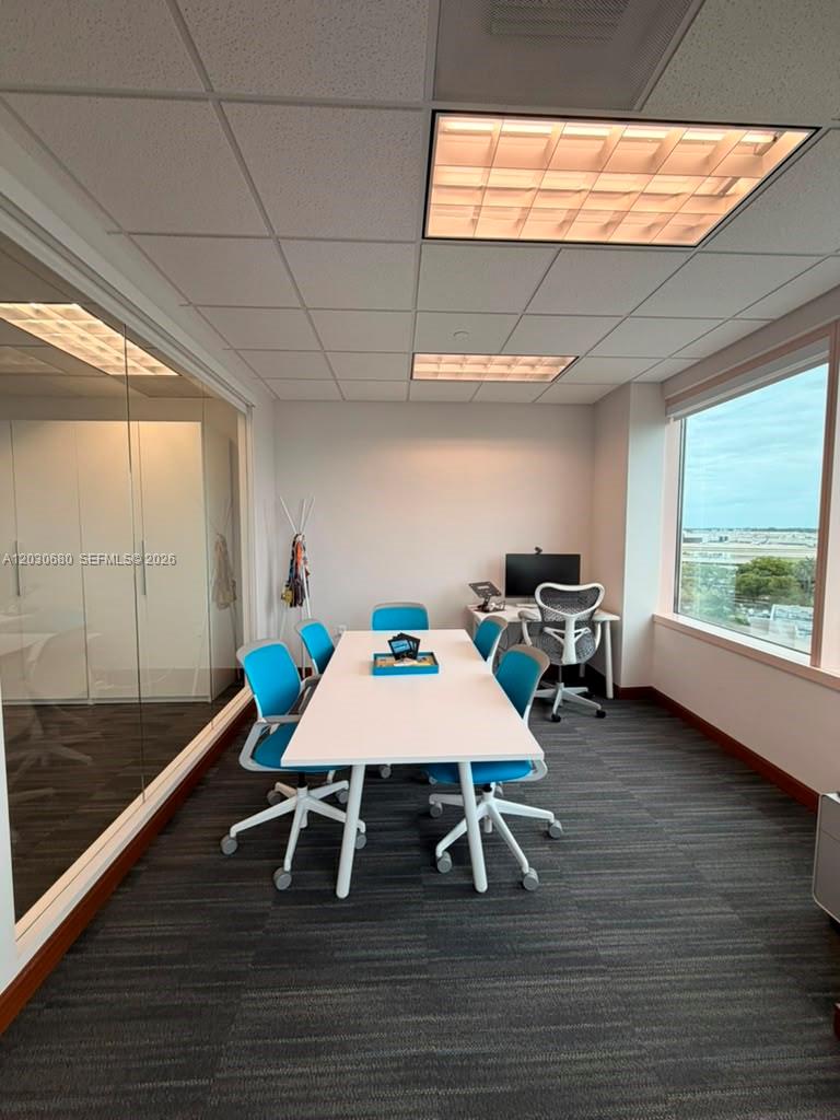 A conference room features a white table, blue chairs, a desk, and large windows — 1000 NW 57 Ct # 930, Miami FL 33126, MIAMI, FL