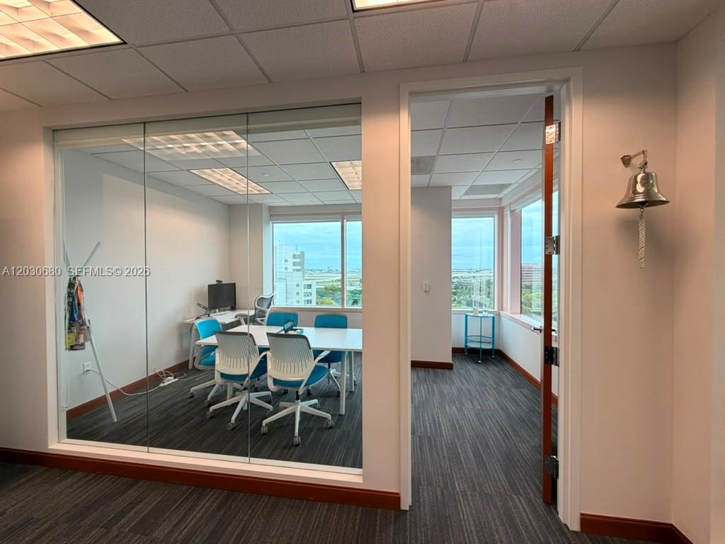 A glass-walled office with a conference table and chairs sits next to an open doorway — 1000 NW 57 Ct # 930, Miami FL 33126, MIAMI, FL