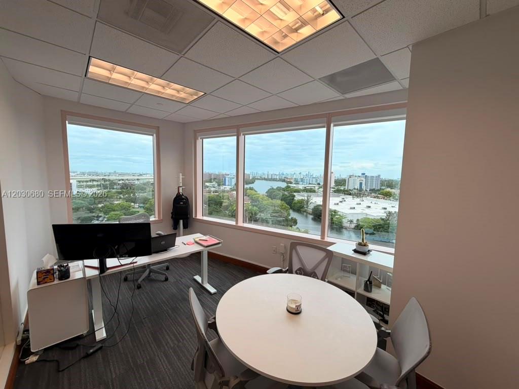 An office space features a desk, a round meeting table, and large windows overlooking a city — 1000 NW 57 Ct # 930, Miami FL 33126, MIAMI, FL