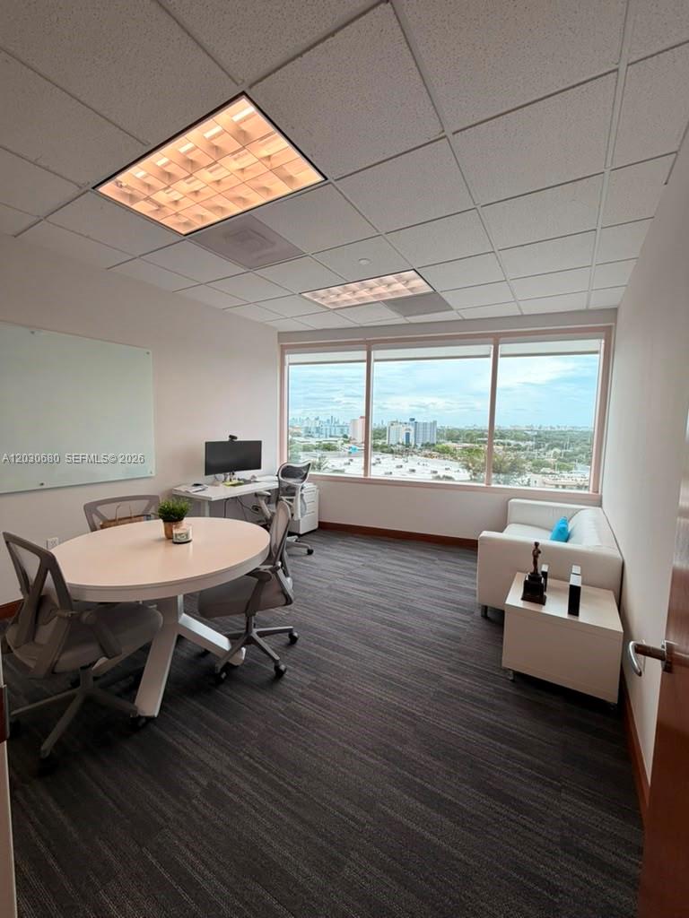 An office features a round table, a desk, a white sofa, and large windows — 1000 NW 57 Ct # 930, Miami FL 33126, MIAMI, FL