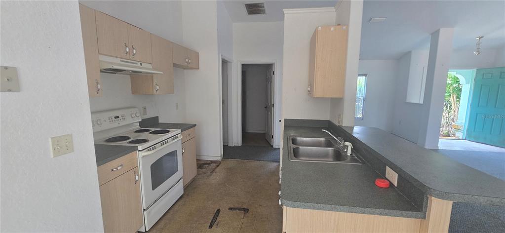 A living room with gray carpet, white walls, a large window, and a breakfast bar — 12771 SW 58TH CIRCLE, OCALA, FL