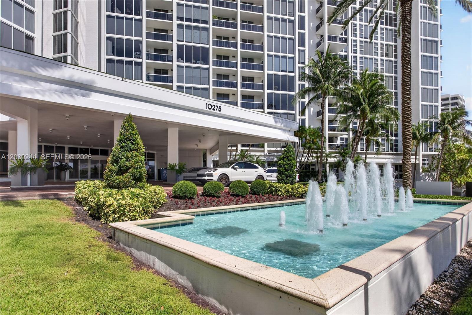 A multi-story residential building features a covered entrance, a fountain, and landscaped grounds — 10275 Collins Ave # 1521, Bal Harbour FL 33154, BAL HARBOUR, FL