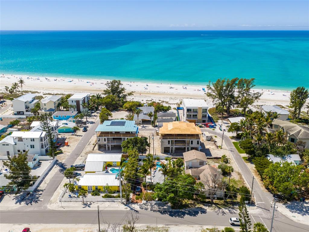 An aerial view shows a white multi-story house under construction near a sandy beach — 107 TUNA STREET, ANNA MARIA, FL