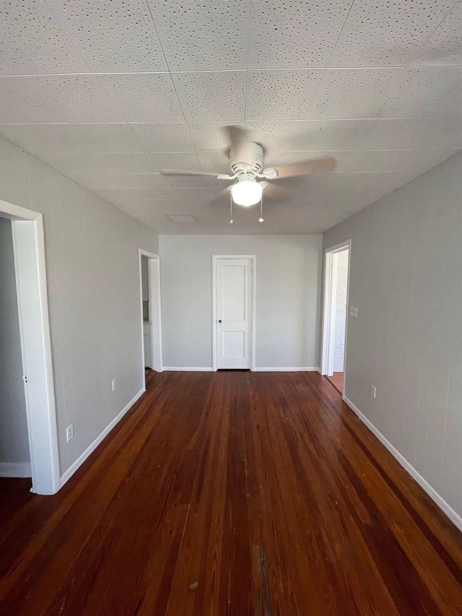 An empty room features light gray walls, hardwood floors, a ceiling fan, and three doorways — 736 Omar Road # 1, West Palm Beach FL 33405, WEST PALM BEACH, FL