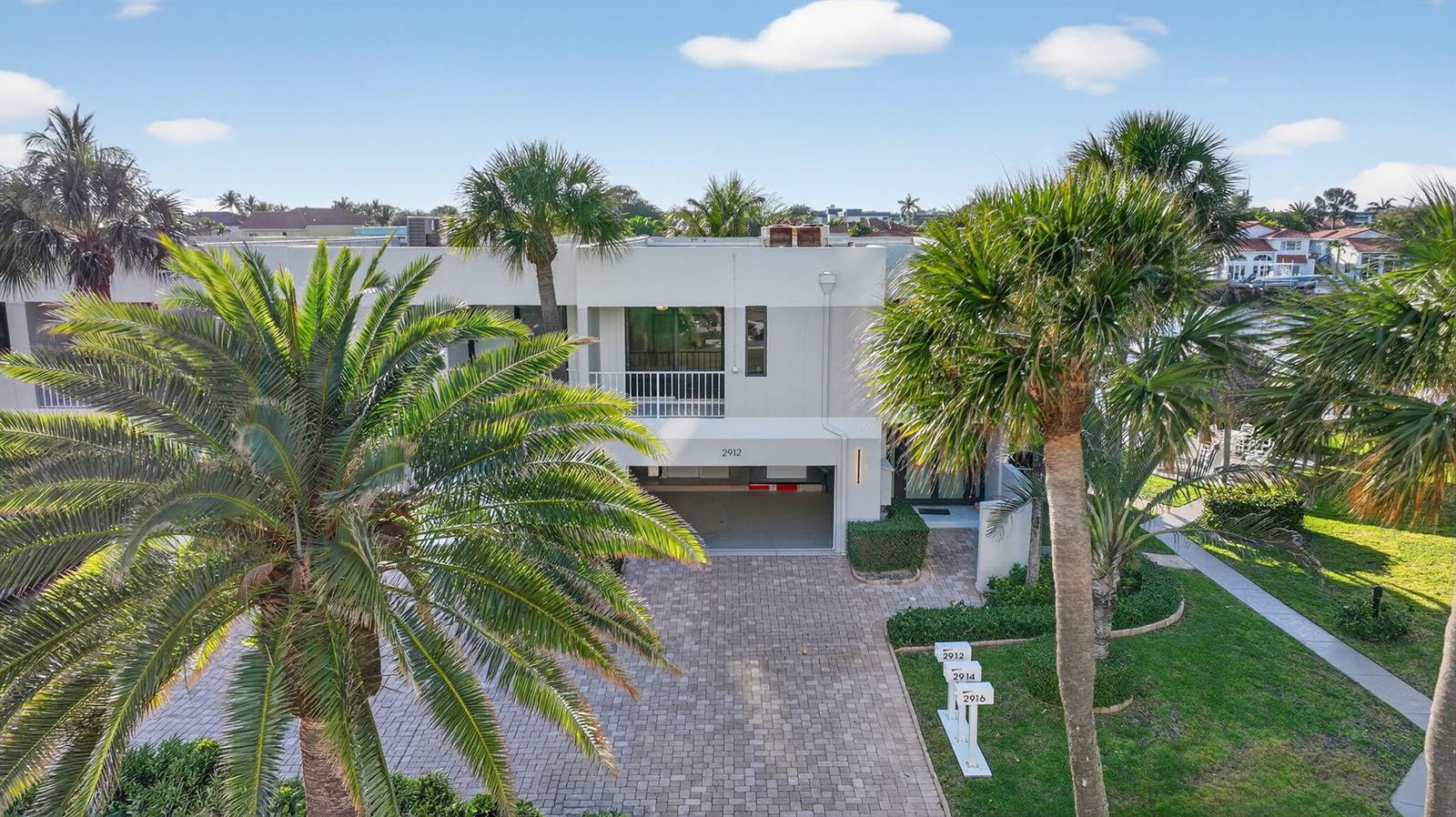 An aerial view shows a two-story building with a covered parking area and palm trees — 2912 S Ocean Boulevard S, Highland Beach FL 33487, HIGHLAND BEACH, FL