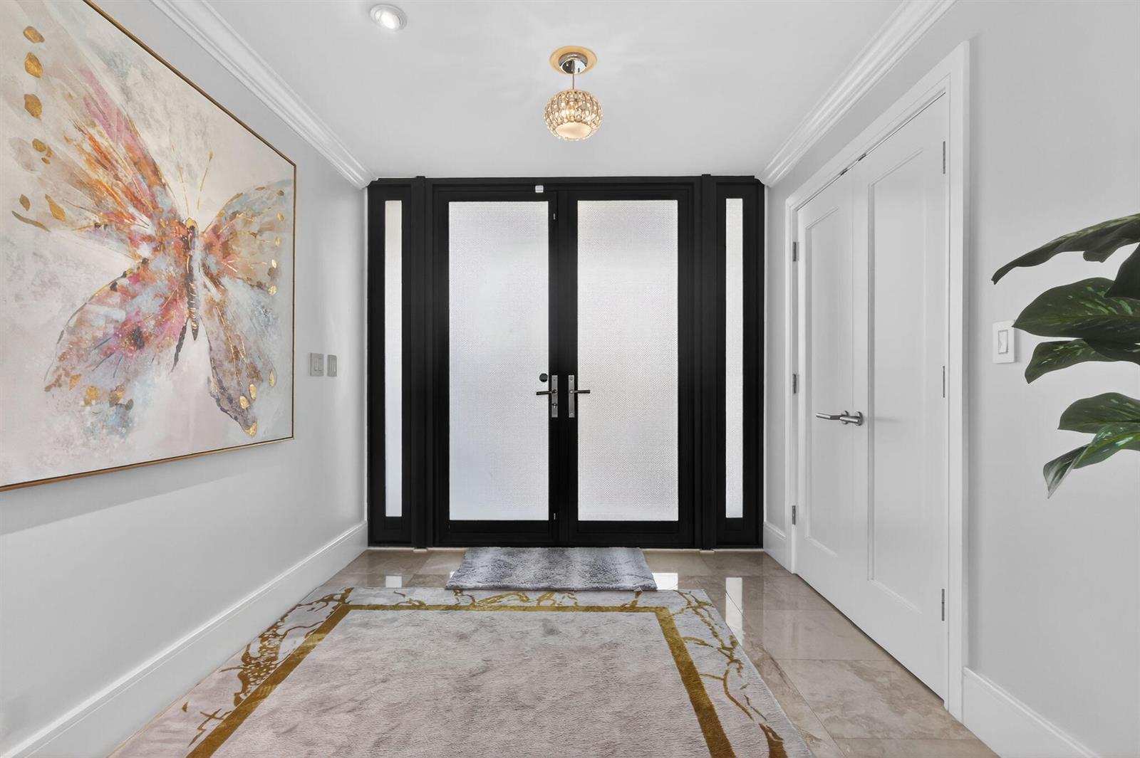 An entryway features a double front door with frosted glass, a butterfly painting, and tile flooring — 2912 S Ocean Boulevard S, Highland Beach FL 33487, HIGHLAND BEACH, FL