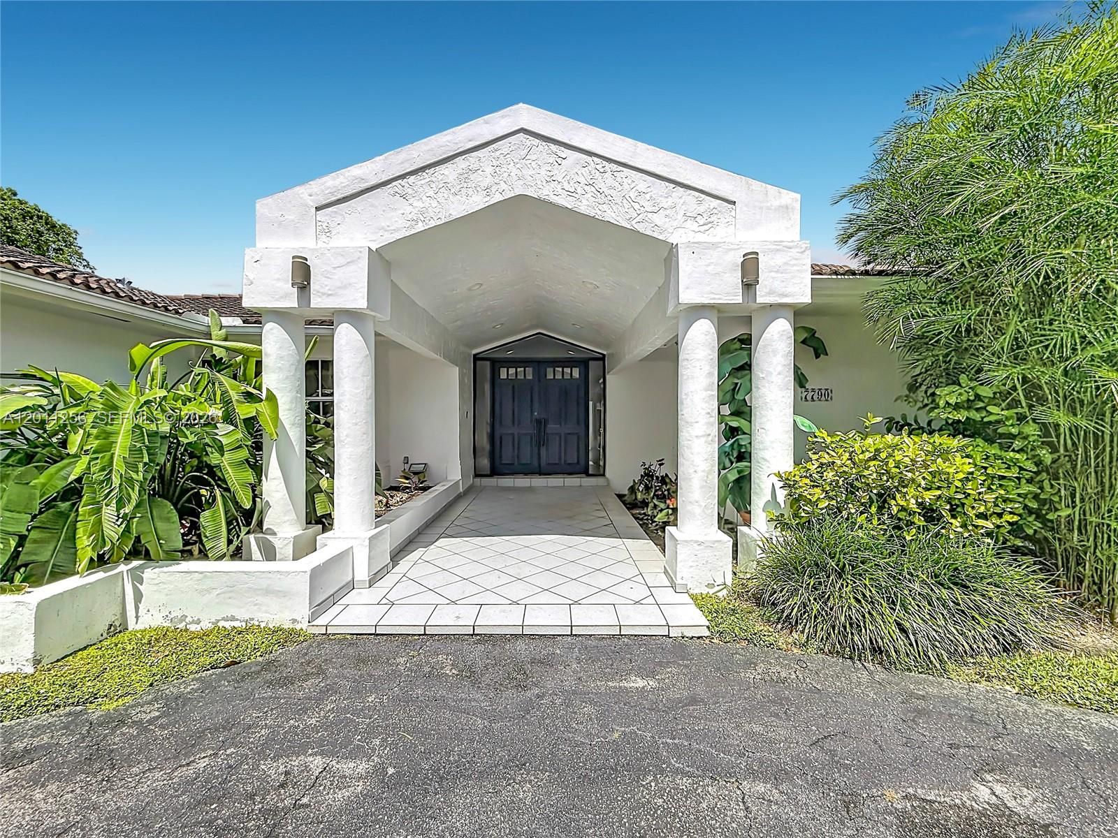 A backyard features a swimming pool and attached hot tub surrounded by a stone patio — 7790 SW 91st Ave, Miami FL 33173, MIAMI, FL
