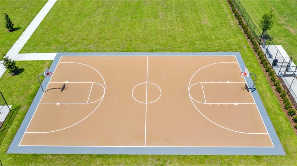 An aerial view of an outdoor basketball court with a tan surface and white markings — 3128 NAMASTE ROAD, CLERMONT, FL