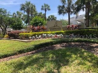 A sign for Tradewinds Condominiums stands in a landscaped garden with palm trees and shrubs — 1025 S HIAWASSEE ROAD UNIT 2226, ORLANDO, FL