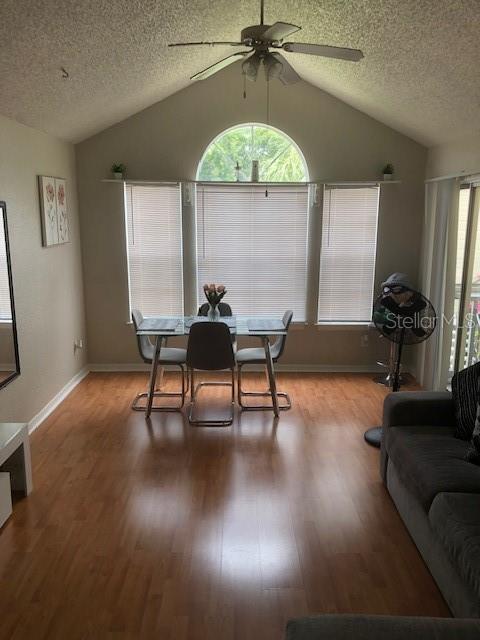 A dining area with a vaulted ceiling, wood-look flooring, and a large arched window — 1025 S HIAWASSEE ROAD UNIT 2226, ORLANDO, FL
