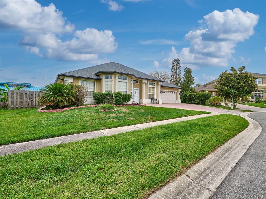 A single-story house with a beige exterior, a gray roof, and a front lawn — 407 THUNDER GULCH COURT, ORLANDO, FL