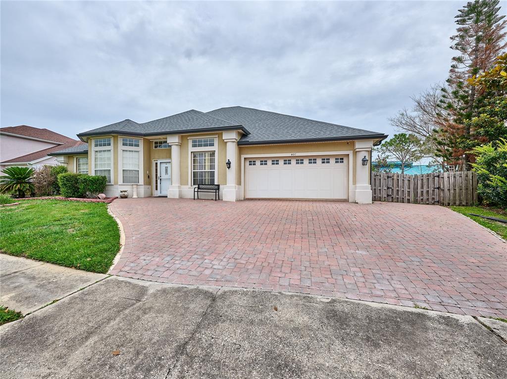 A single-story house with a brick paver driveway, a two-car garage, and a tan exterior — 407 THUNDER GULCH COURT, ORLANDO, FL