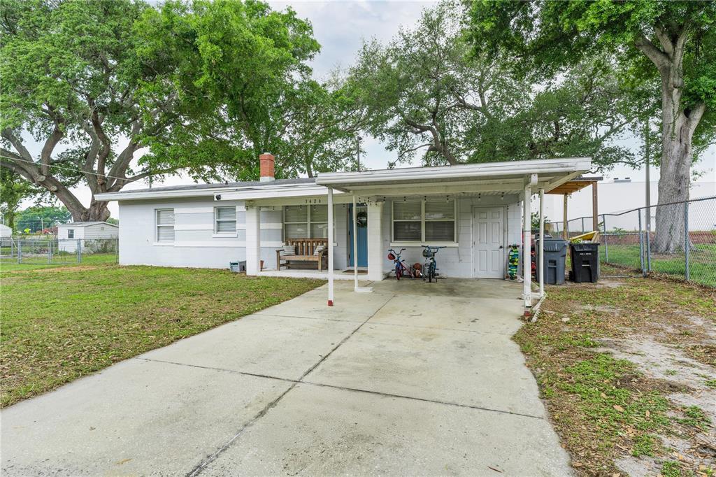 A single-story house with a white exterior, a concrete driveway, and a covered carport — 3426 HICKORY STREET NW, WINTER HAVEN, FL