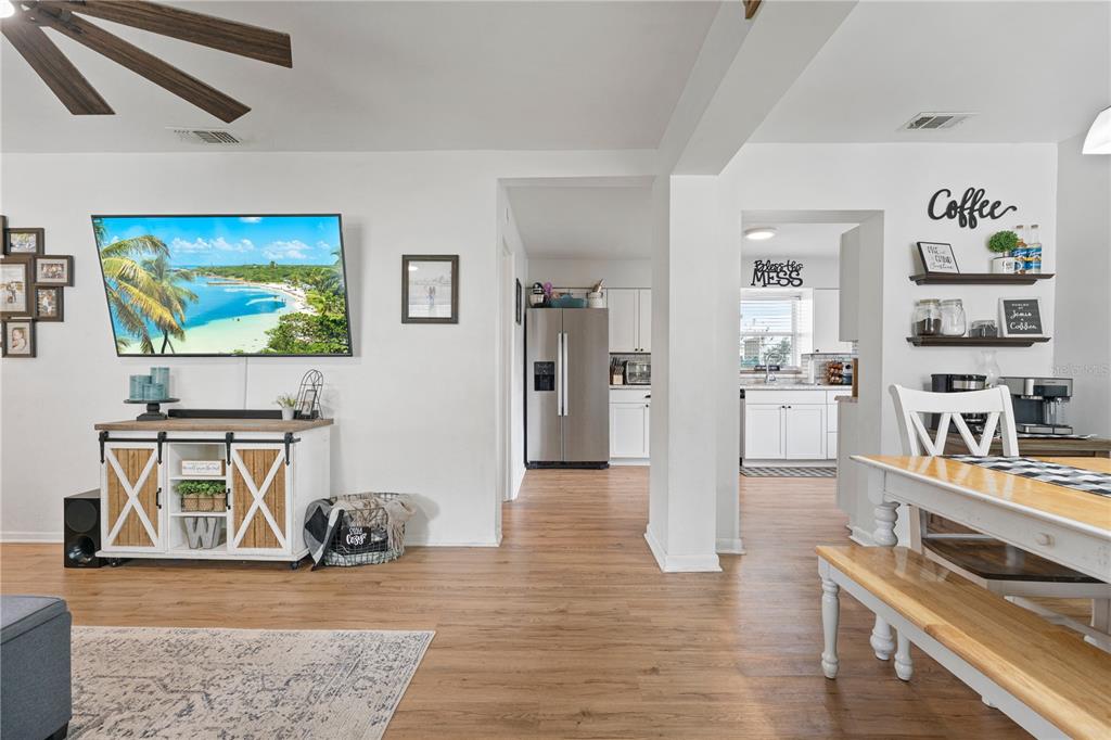 A living room with a television, media console, and a view into the kitchen — 3426 HICKORY STREET NW, WINTER HAVEN, FL