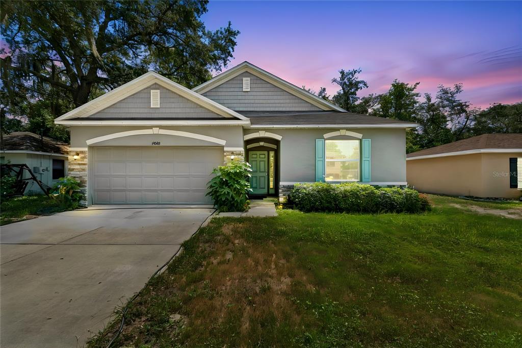 A single-story house with a gray garage, light green front door, and a grassy lawn — 4068 MENDOTA AVENUE, SPRING HILL, FL