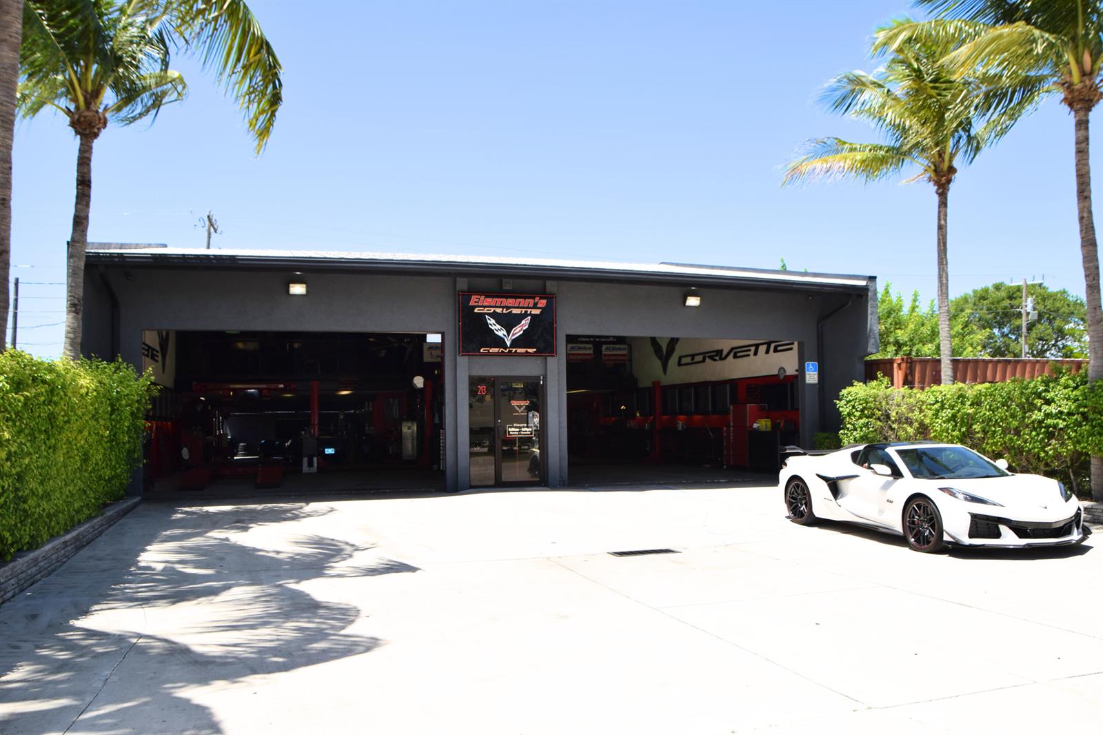 A white Corvette is parked in front of a commercial automotive repair shop with two bays — 213 Venus Street, Jupiter FL 33458, JUPITER, FL