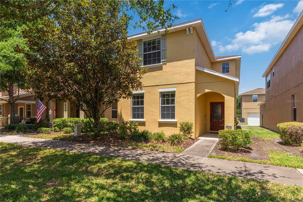 A two-story yellow stucco house with a front porch and a sidewalk — 9040 ASPEN HOLLOW PLACE, RIVERVIEW, FL