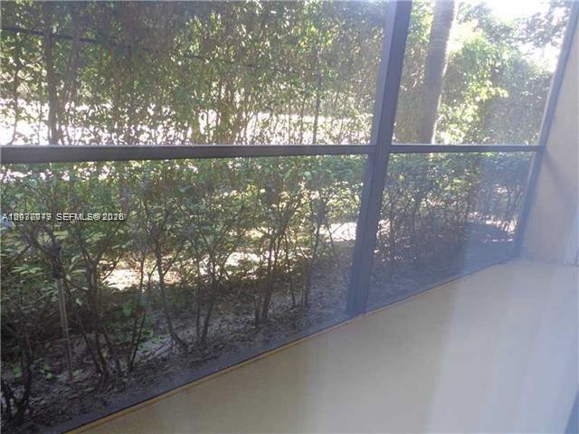 A screened-in porch overlooks a row of dense green hedges — 1267 SW 46th Ave # 2315, Pompano Beach FL 33069, POMPANO BEACH, FL