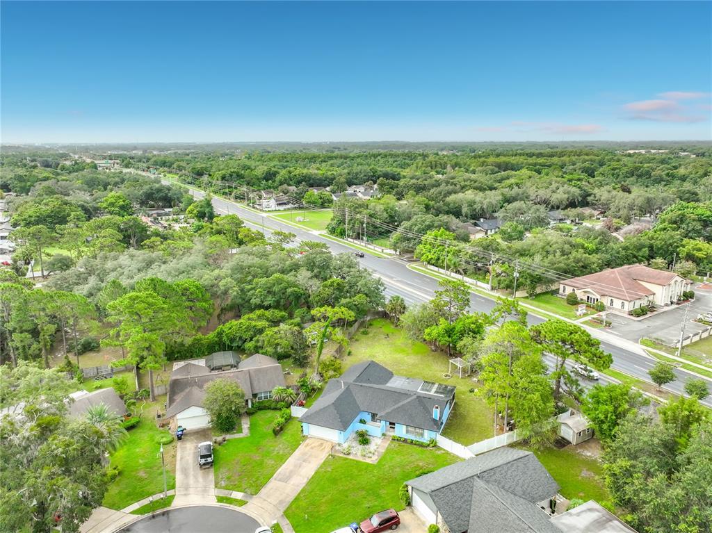 An aerial view shows a suburban neighborhood with houses, a road, and surrounding trees — 9216 AMITY COURT, ORLANDO, FL