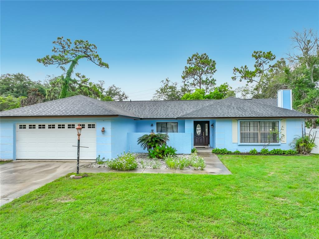A single-story light blue house with a two-car garage and a front lawn — 9216 AMITY COURT, ORLANDO, FL