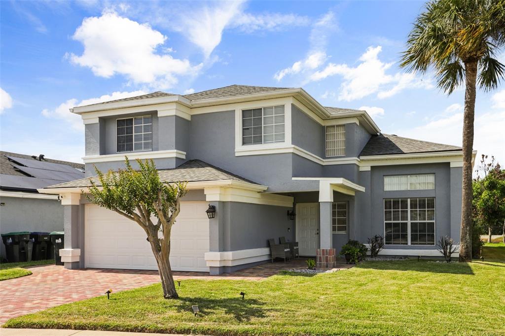 A two-story gray house with a white trim, a two-car garage, and a palm tree — 1617 MAPLESTEAD COURT, ORLANDO, FL