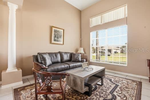 A living room features a dark leather sofa, a wooden coffee table, and a decorative column — 1617 MAPLESTEAD COURT, ORLANDO, FL