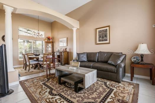 A living room with a dark leather sofa, a wooden coffee table, and a dining area — 1617 MAPLESTEAD COURT, ORLANDO, FL