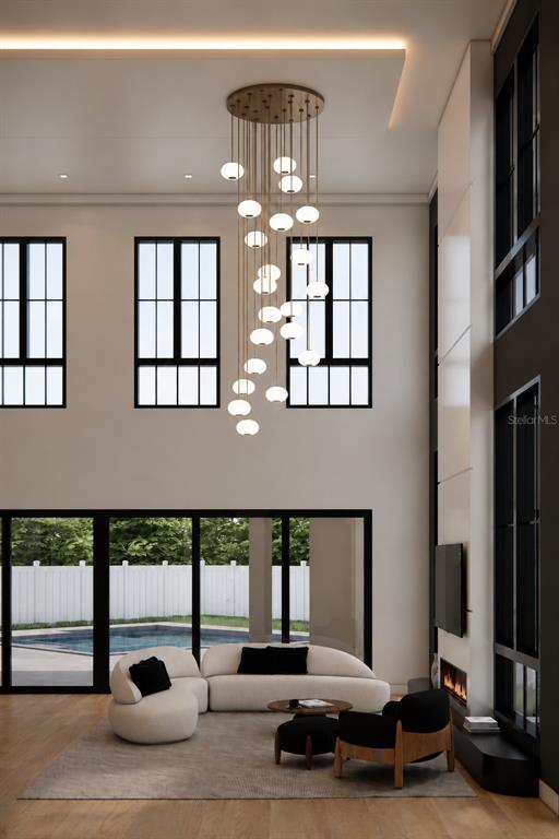 This is a rendering of a modern living room with a tall chandelier and pool view — 826 GARDEN PLAZA, ORLANDO, FL